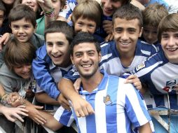 El futbolista mexicano posa junto a un grupo de aficionados. EFE  /