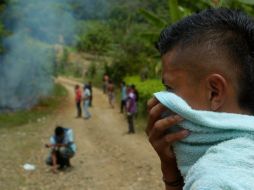 Un joven se cubre de los gases lacrimógenos durante un bloqueo realizado por los nativos, pues están cansados de los choques.EFE  /