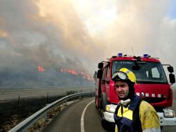 Bomberos trabajan para sofocar el incendio que desde el domingo ha arrasado con 150 hectáreas. EFE  /
