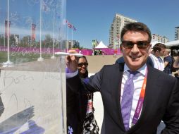 Coe firma su nombre en la pared de la paz a la entrada de las villas olímpicas. AFP  /