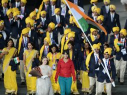 La voluntaria (centro) se cólo mientras desfilaba la delegación olímpica de India. XINHUA  /