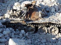 Un hombre observa un tanque del ejército sirio destrozado. Militares continúan los ataques sobre los insurgentes en Aleppo. REUTERS  /