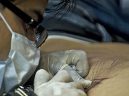 Un tatuador trabajando en la convención Tattoo Art Mex. AFP  /