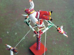 Hombres pájaro… de plástico.  Pequeños luchadores de plástico dejan el ring para fungir como uno de los voladores de Papantla.  /