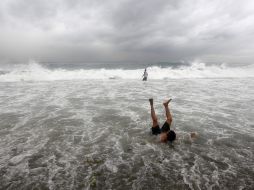 Dos hombres se bañan en el mar, donde se registra fuerte oleaje por el paso de la tormenta tropical. ARCHIVO  /