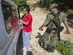 Un forense y un soldado del Ejército junto al camión que traslada los cuerpos de las víctimas. EFE  /