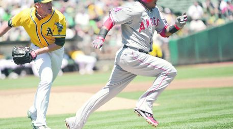 Córrele. Erick Aybar, de los Angelinos, corre a primera base, perseguido por el pitcher Dan Straily. AFP  /
