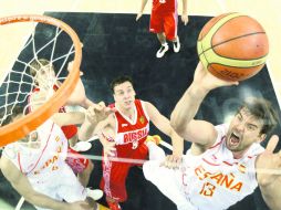 Marc Gasol (13) encesta una pelota ante la mirada del defensa ruso Sasha Kaun (8), que nada pudo hacer para evitar la anotación. AFP  /