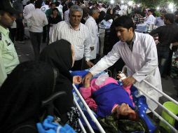 Un médico iraní atiende a una mujer herida, tras el sismo. AFP  /