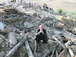 Un residente del pueblo de Baje-Baj permanece sobre los escombros de su casa destruida por los terremotos. AFP  /