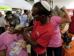 Una niña se prueba una máscara de gas en un centro de distribución en Jerusalén. EFE  /