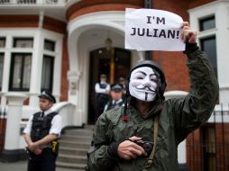 Simpatizantes de Assange y policías aguardan en la puerta de la embajada de Ecuador en Londres. AFP  /