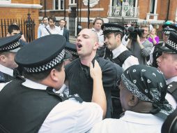 NO SE VA.- Un simpatizante de Julian Assange es arrestado afuera de la embajada de Ecuador en Londres. AFP  /