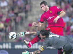 El delantero israelí del Mallorca, Tomer Hemed, intenta rematar ante el guardameta argentino del Espanyol, Cristian Álvarez. EFE  /