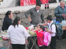PRIMER DÍA DE CLASES. Afuera de la Escuela Urbana 108 y 109 los padres de familia compran el desayuno de sus pequeños.  /