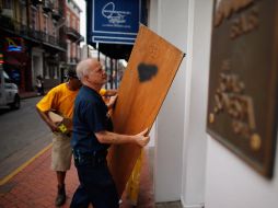 Trabajadores de un establecimiento, en Nueva Orleans, se preparan ante el impacto de ''Isaac''. AFP  /