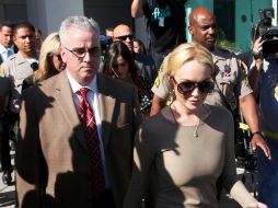 Una imagen cada día más común: Lindsay Lohan escoltada por agentes de la policía. ARCHIVO  /