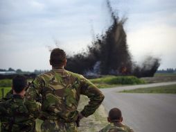 Varios soldados holandeses observan como una bomba de la II Guerra Mundial explota cerca de la terminal C. EFE  /