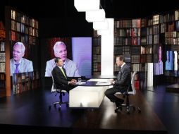 El presidente Rafael Correa (i) y Julian Assange (pantallas) en entrevista con el periodista Jorge Gestoso. AFP  /