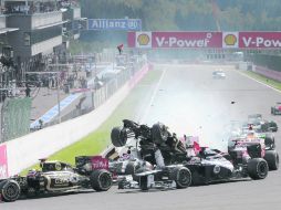 El auto de Romain Grosjean sale proyectado, mientras que Sergio Pérez (abajo de él) no puede hacer nada para evitar el choque. EFE  /