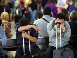 Pasajeros descansan mientras esperan el embarque de su vuelo de la aerlínea Lufthansa, en el aeropuerto de Fráncfort. EFE  /