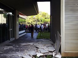 Personas observan el daño causado en varios edificios tras el sismo. AP  /