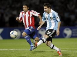 Lionel Messi (d) de Argentina juega la bola ante la defensa de Richard Ortíz (i) de Paraguay. EFE  /