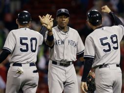 Curtis Granderson (c) celebra el triunfo con Mick Kelleher (50) y Rob Thomson (59). AP  /