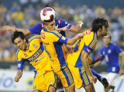 Jorge Torres (C) de Tigres disputa el balón con Hugo Pavone (atrás) de Cruz Azul. EFE  /