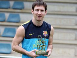 Lionel Messi se muestra feliz sosteniendo su reconocimiento como Mejor Jugador de esta temporada (Twitter ‏@FCBarcelonaFl). ESPECIAL  /