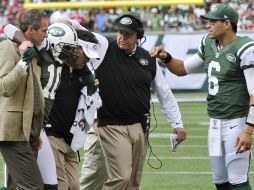 Santonio Holmes (izq) sale lesionado en el partido los 49ers. AP  /