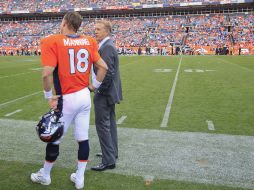 Ya con el triunfo en la bolsa, Manning se puso a charlar con el presidente de operaciones del equipo John Elway. AP  /