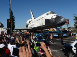 Espectadores se congregaron en las calles para ver el paso del transbordador. AFP  /