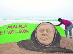 El artista hindú Sudarsan Pattnaik le da un toque final a la escultura hecha a mano en honor a la paquistaní Malala Yousafzai. AFP  /