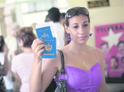 Una mujer muestra su pasaporte que, en enero de 2013 ya no será necesario contar con la “tarjeta blanca. AP  /