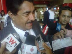 Ramiro Hernández muestra su cheque quincenal ante representantes de los medios.  /