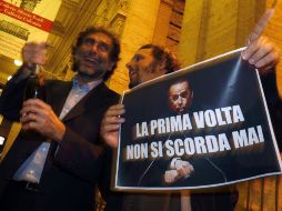 Manifestantes muestran un letrero que dice ''La primera vez nunca se olvida'', para celebrar la condena de Berlusconi. REUTERS  /