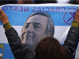Una mujer sostiene una pancarta con la leyenda ''gracias Néstor'' y la foto del exmandatario. ARCHIVO  /