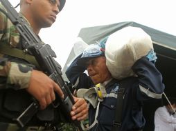 Un oficial peruano carga una bolsa con clorhidrato de cocaína para ser lanzada a un horno de incineración. EFE  /