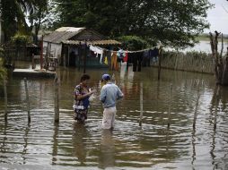 Una mujer recibe una entrega de verdudas en su casa, inundada por ''Sandy''. REUTERS  /