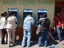 Guatemaltecos usan teléfonos públicos, tras el terremoto que afectó al país centroamericano esta mañana. AFP  /