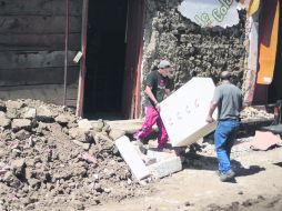 Dos hombres rescatan algunas de sus pertenencias,luego del sismo de 7.4 grados que afectó varias provincias fronterizas con México. AFP  /