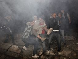 Jóvenes palestinos evacuna un edificio tras los bombardeos.  AFP  /