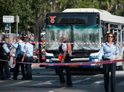 Oficiales observan el autobús, tras su destrucción en el estallido. XINHUA  /