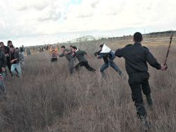 Tensión. Un agente israelí persigue a palestinos en la frontera común. AP  /