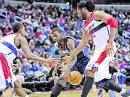 Para nadie. Nené y Bradley Beal (de blanco) pelean la pelota con Michael Kidd. AP  /