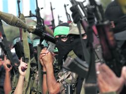 DESAFIANTES. Integrantes de las brigadas Ezzedine al-Qassam, muestran sus armas en el campamento de refugiados Nusseirat.AFP  /
