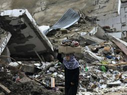 En la imagen, una mujer pasa delante de una vivienda en Gaza, destruída por un ataque israelí. EFE  /