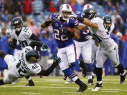 C.J. Spiller (23) corre ante dos defensivos de Jacksonville en el partido. AP  /