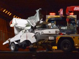 Una grúa retira uno de los automóviles dañados por el colapso del túnel de Sasago. AP  /